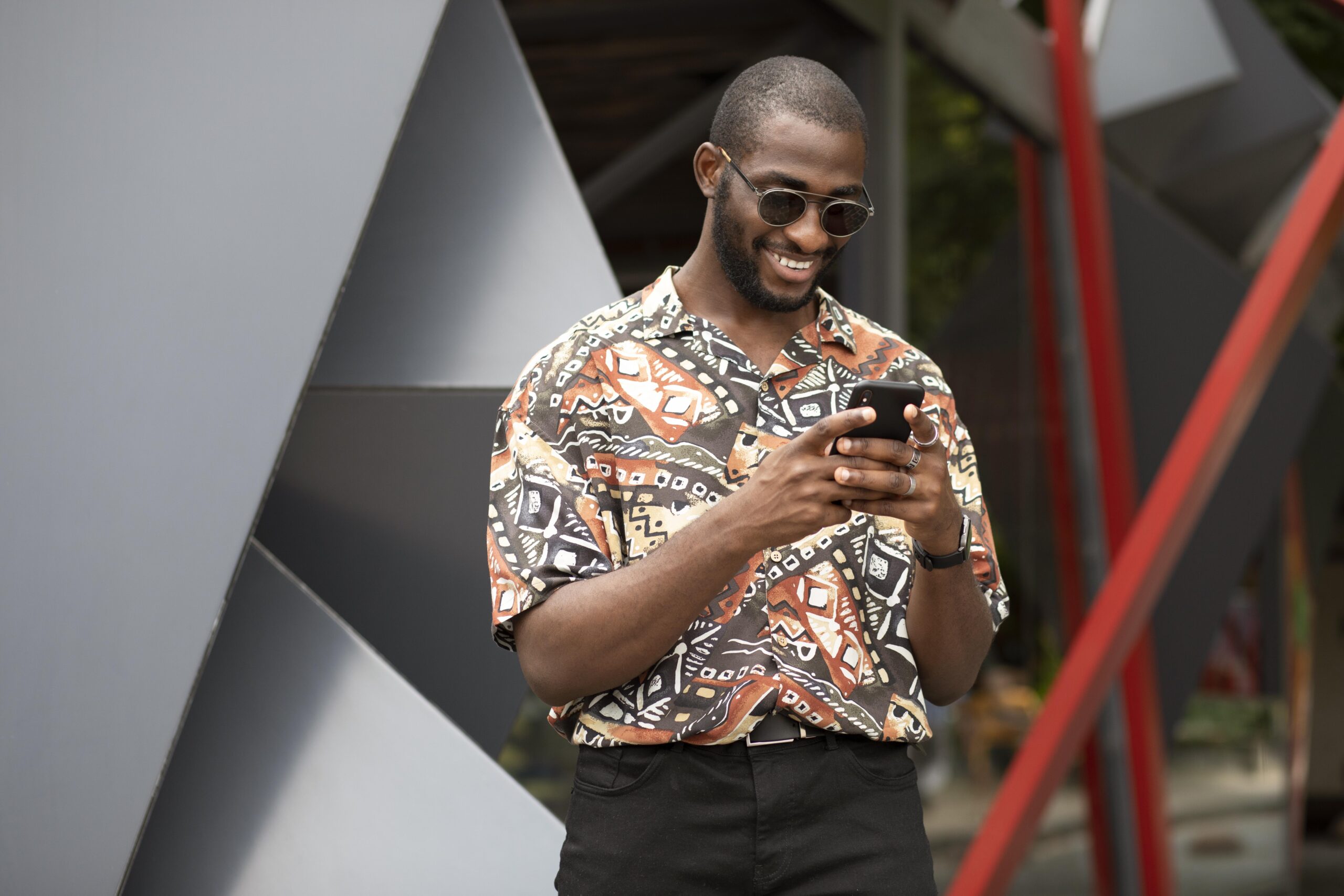 Home handsome man spending time outdoors using modern smartphone